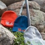 a selection of 3 beanies with Névé embroidered on them, from Gravity Rebel